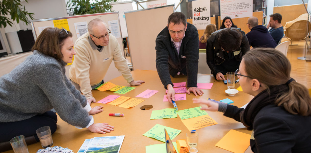 People around a table, brainstorming ideas for service design