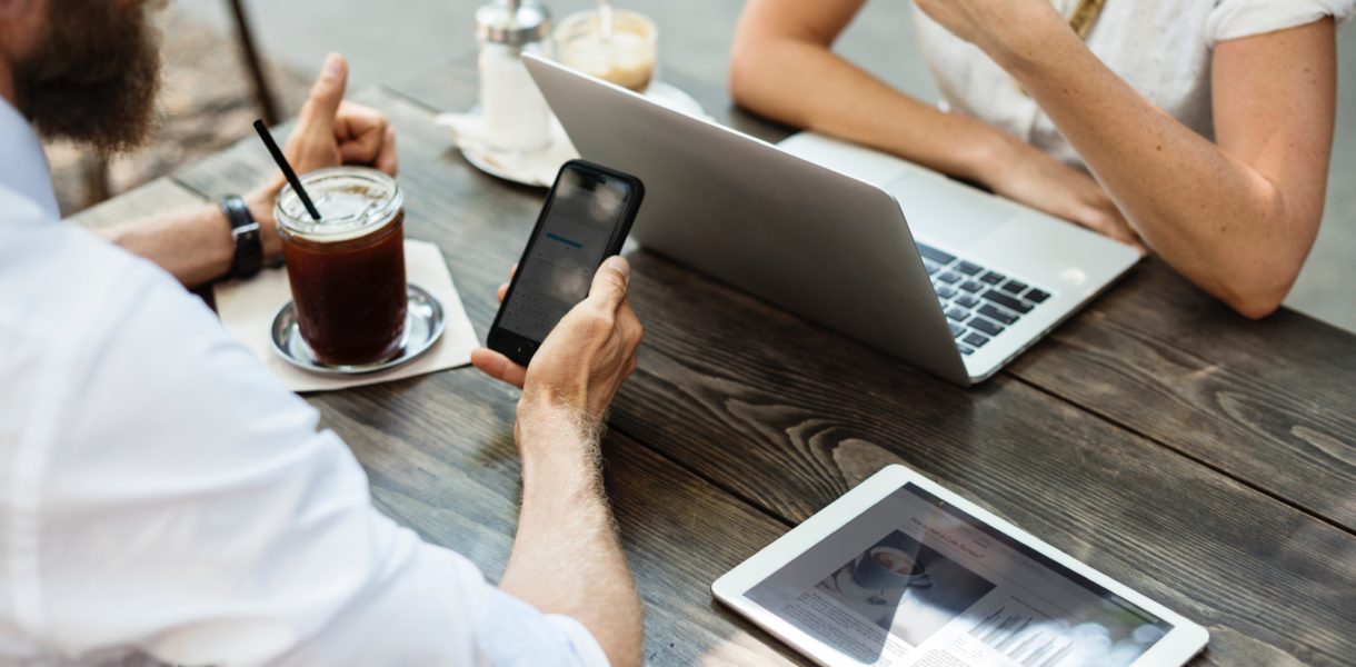 man using mobile and woman using computer
