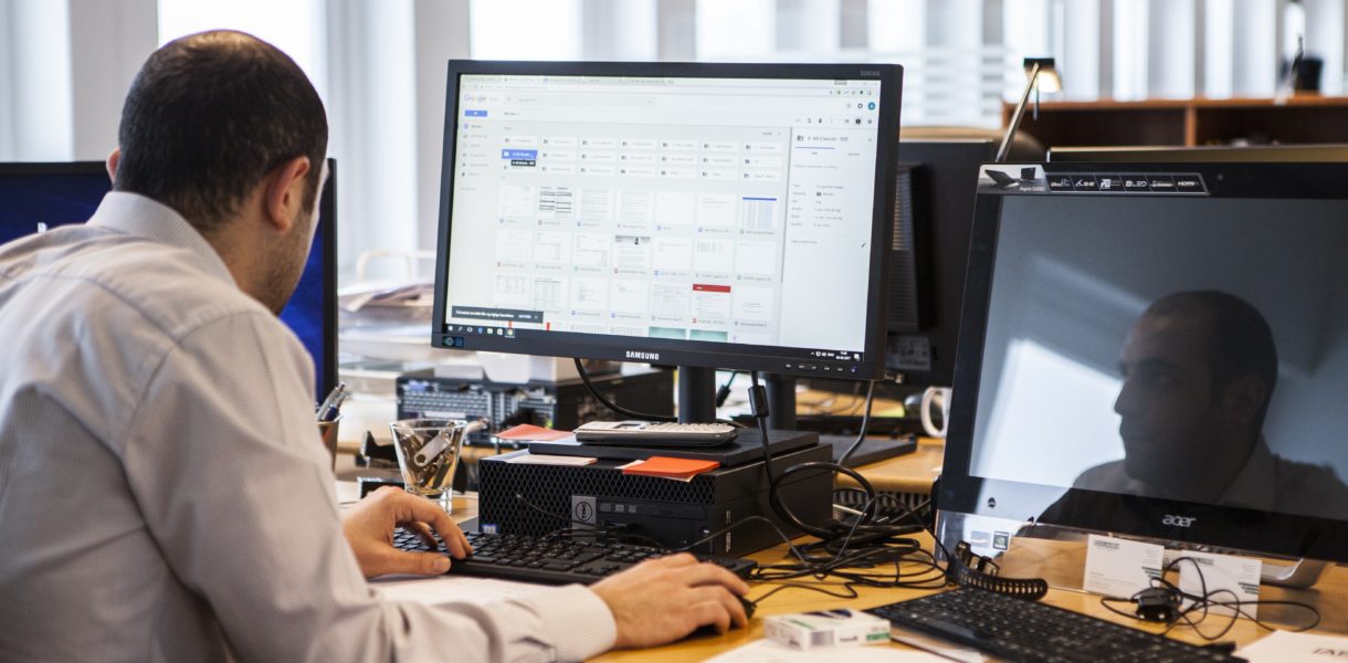 Man sat at a desk using the computer