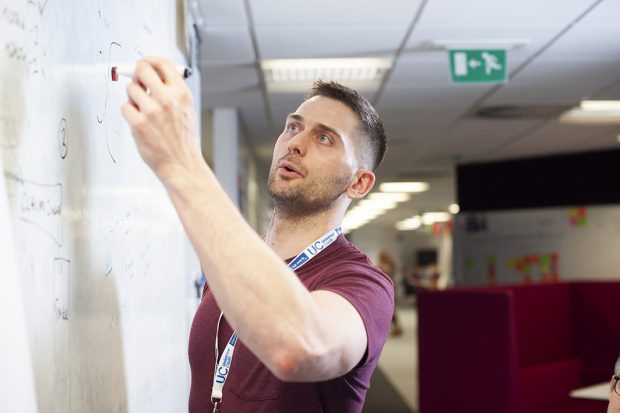 Business analist writing on a whiteboard
