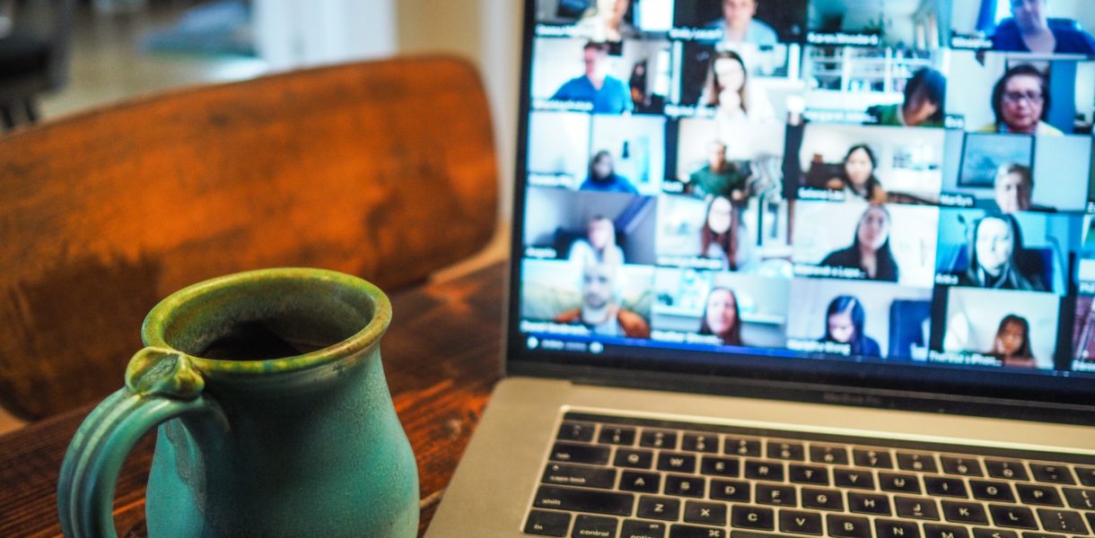 online meeting on laptop next to meeting