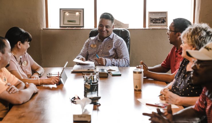 diverse group of people sitting at a table during meeting