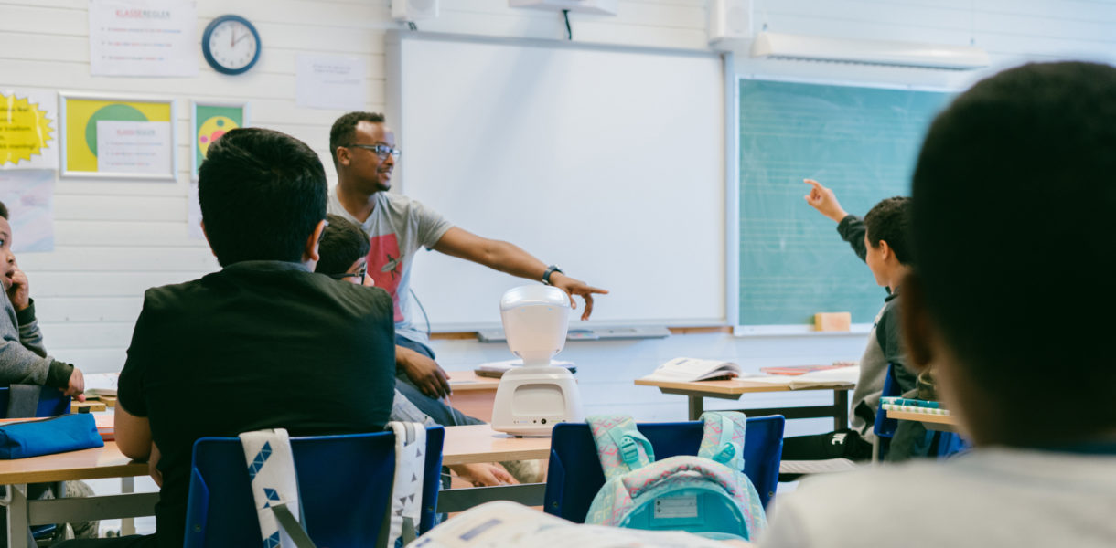 Man teaching a youth class using a robot