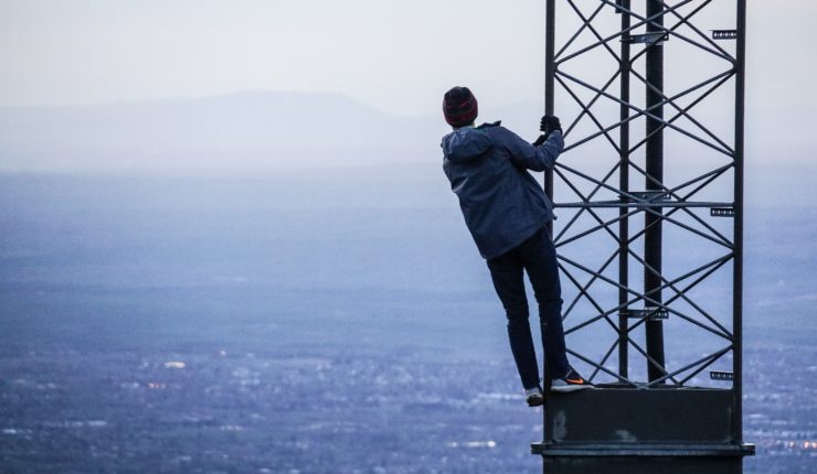 a man climbing a phone mast