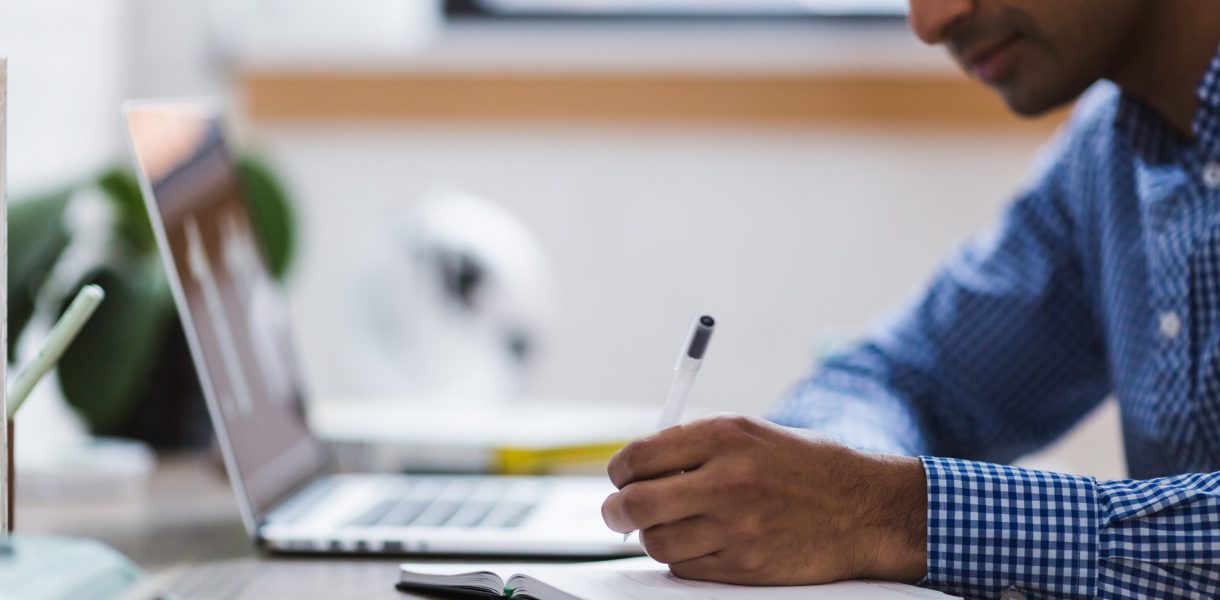 Man using computer and note pad