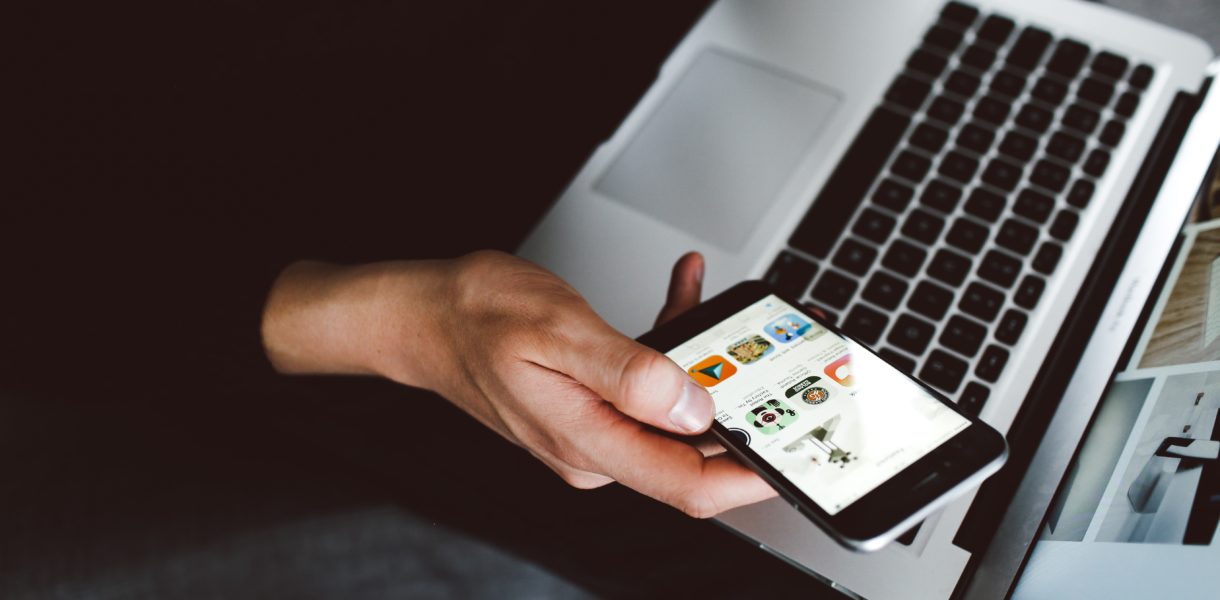 man using phone and laptop