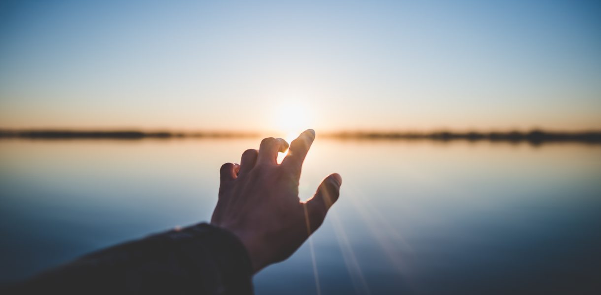Hand stretched towards the sun