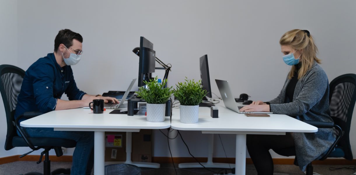 man and woman working in the office with masks on