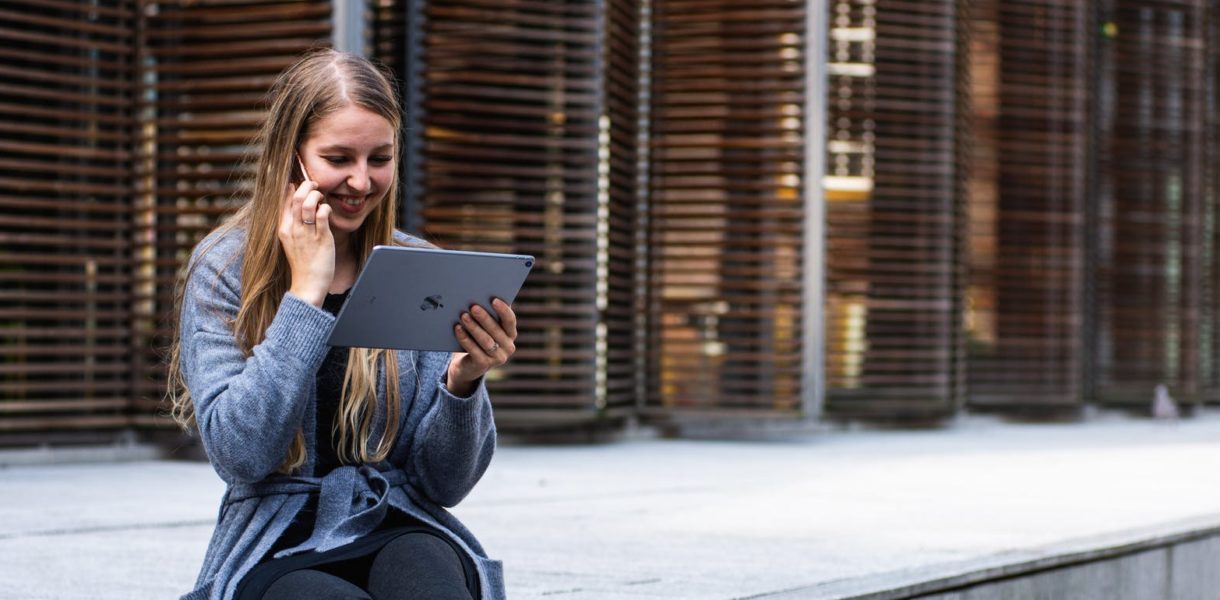woman using ipad and speaking on phone