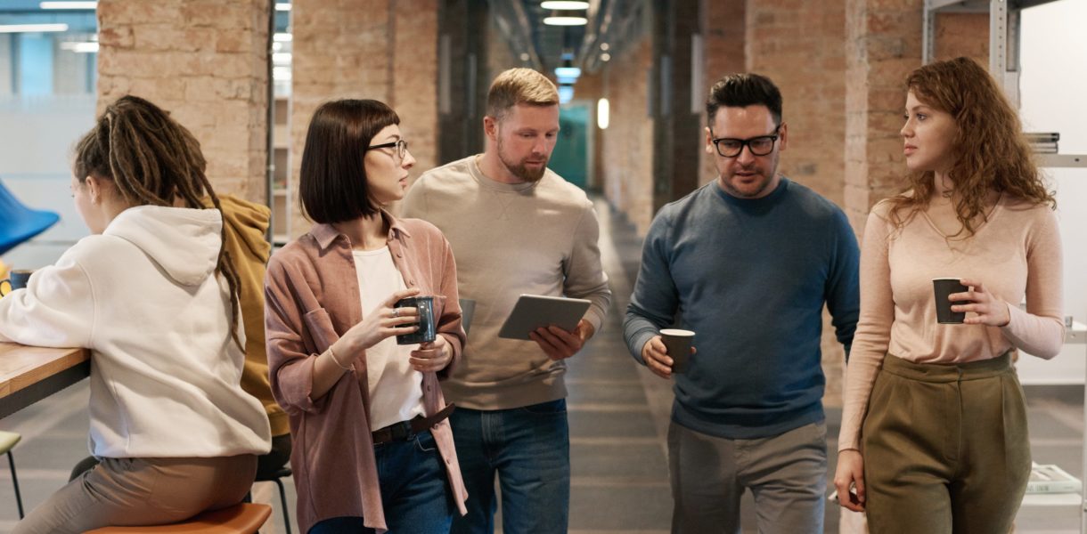 men and women walking in office