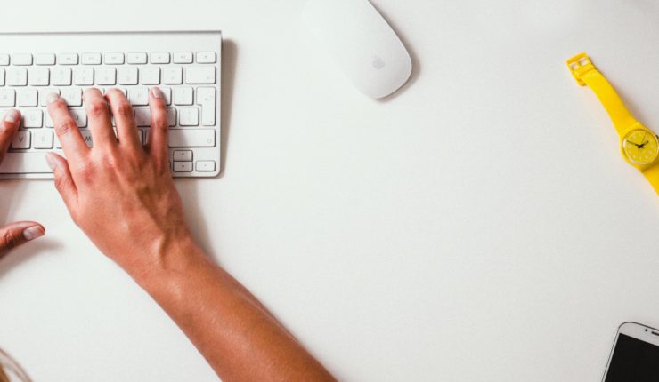 hands typing on a mac keyboard