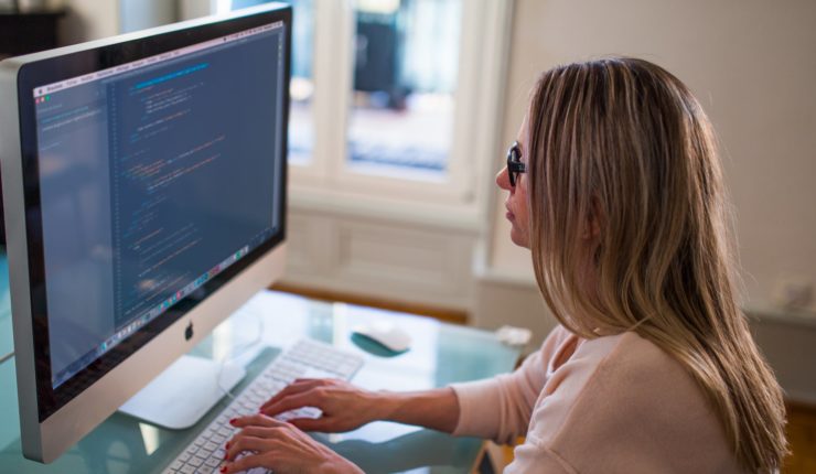 woman sitting at table working on computer
