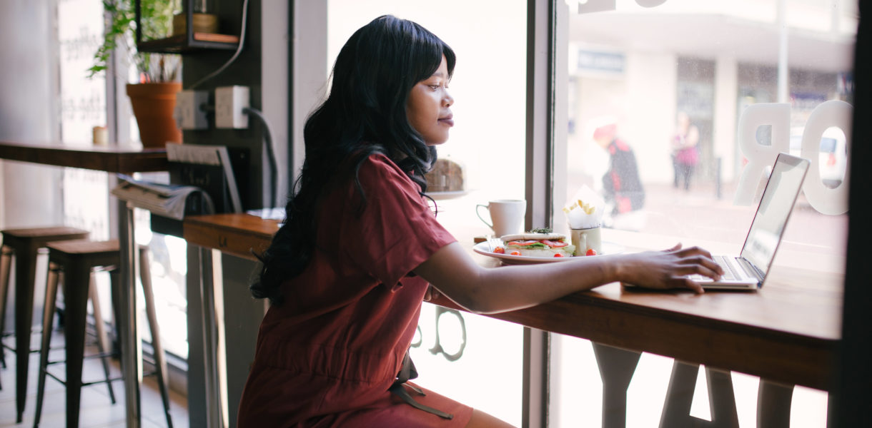 Woman working on laptop in a cafe