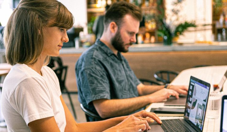 man and woman using computer