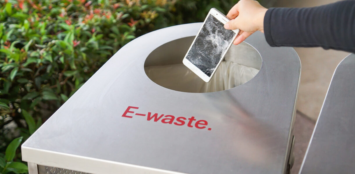 Hand,Dropping,An,Old,,Damaged,Smartphone,Into,A,Bin,For