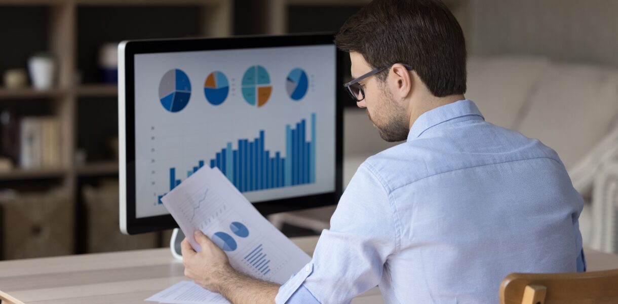 Focused,Millennial,Business,Man,Analyzing,Marketing,Reports,On,Desktop,Monitor,