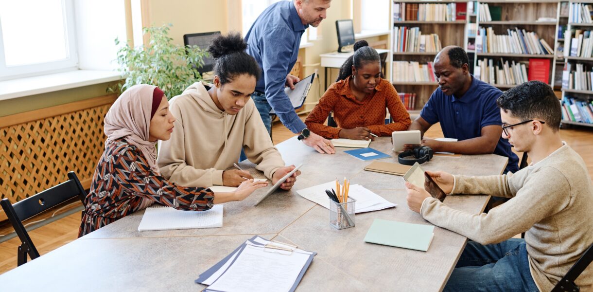 Mature,Caucasian,English,Language,Teacher,Helping,Immigrant,Students,With,Doing