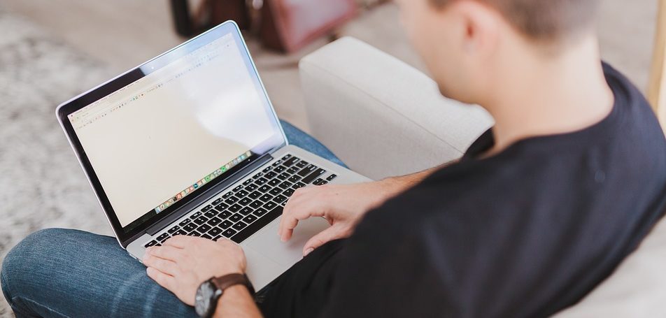 Man typing on a laptop using a public website