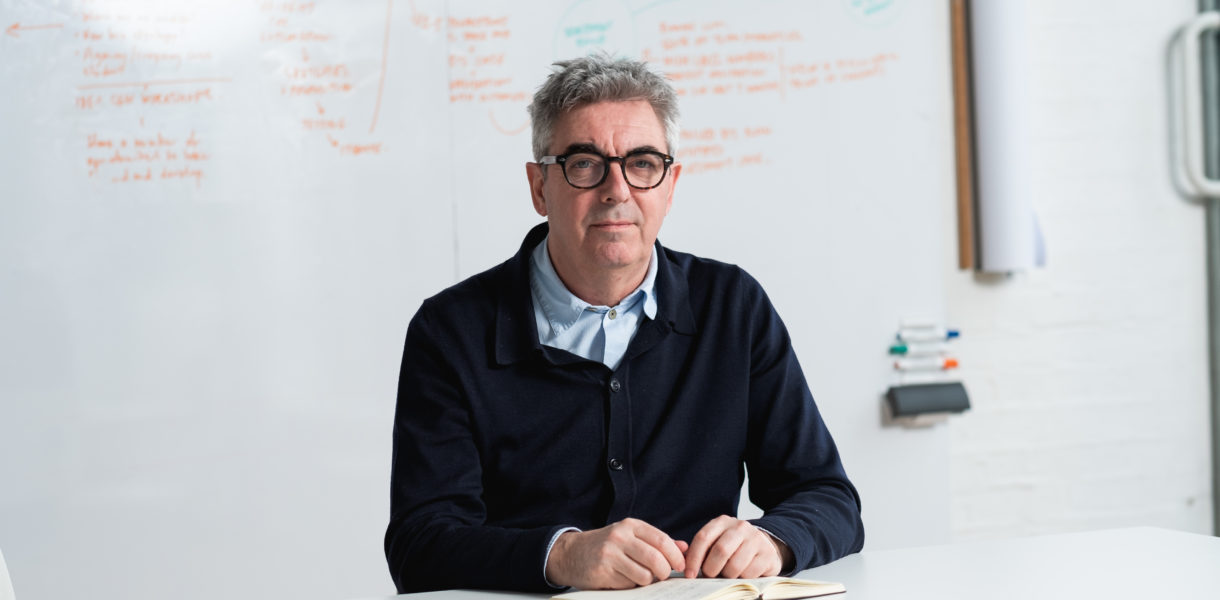 Man in black jumper sat at a desk