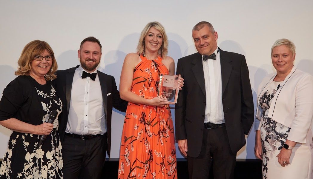 3 people posing after winning an award